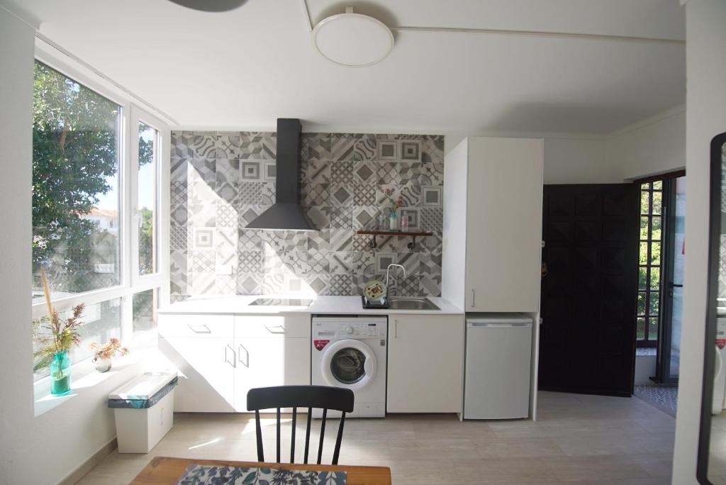 a kitchen with a washer and dryer next to a window at Lei Home in Cascais