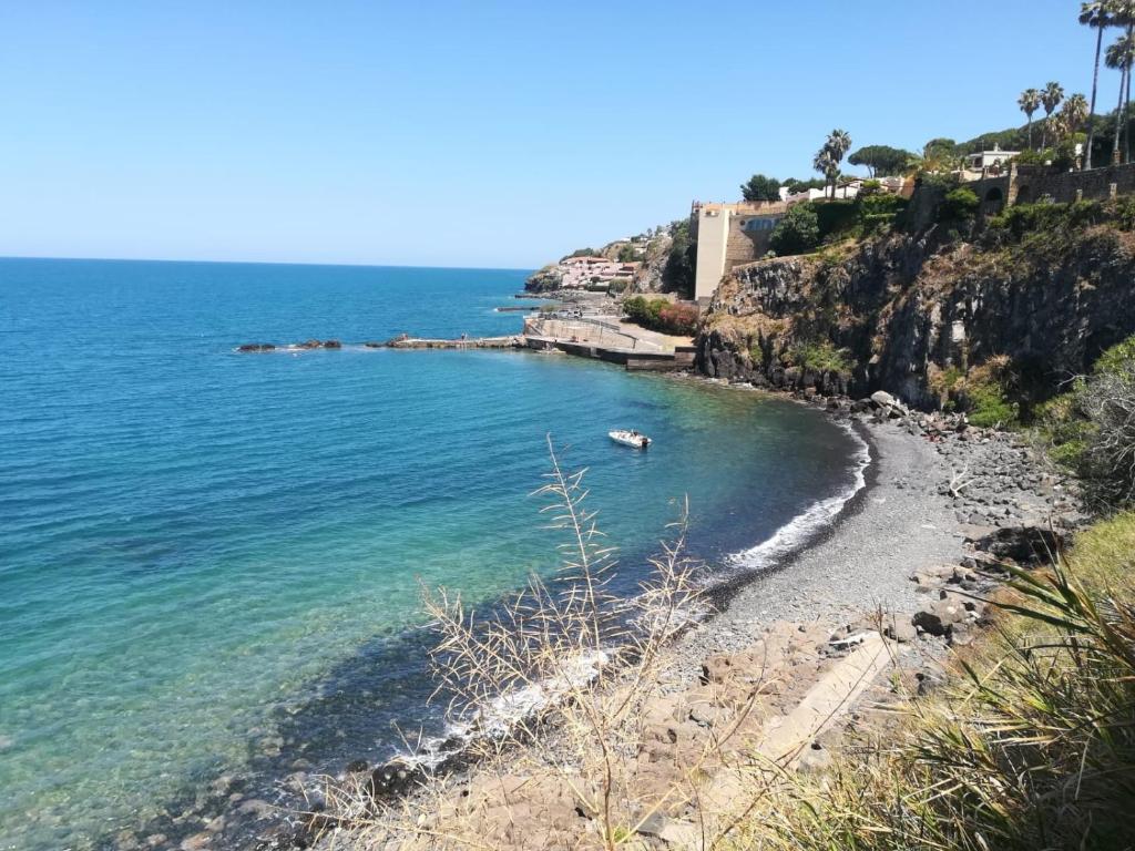 una spiaggia con una barca in acqua di ZagHouses - sea view apartments in Sicily ad Agnone Bagni
