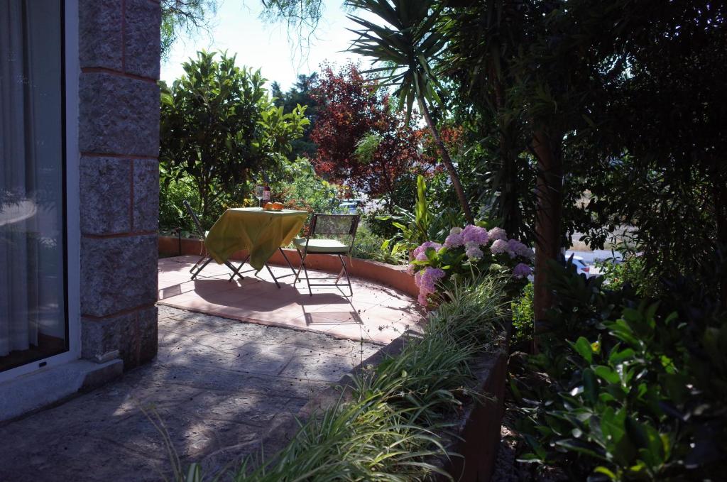 a patio with a yellow chair and a table and flowers at Lei Home in Cascais