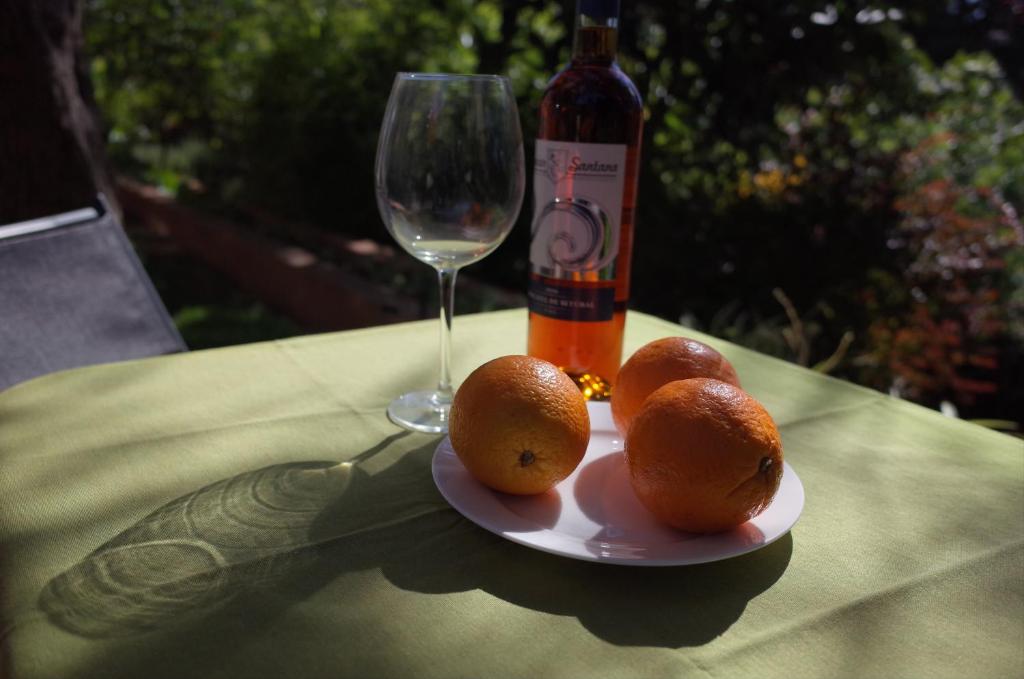 a plate of oranges on a table with a wine glass at Lei Home in Cascais