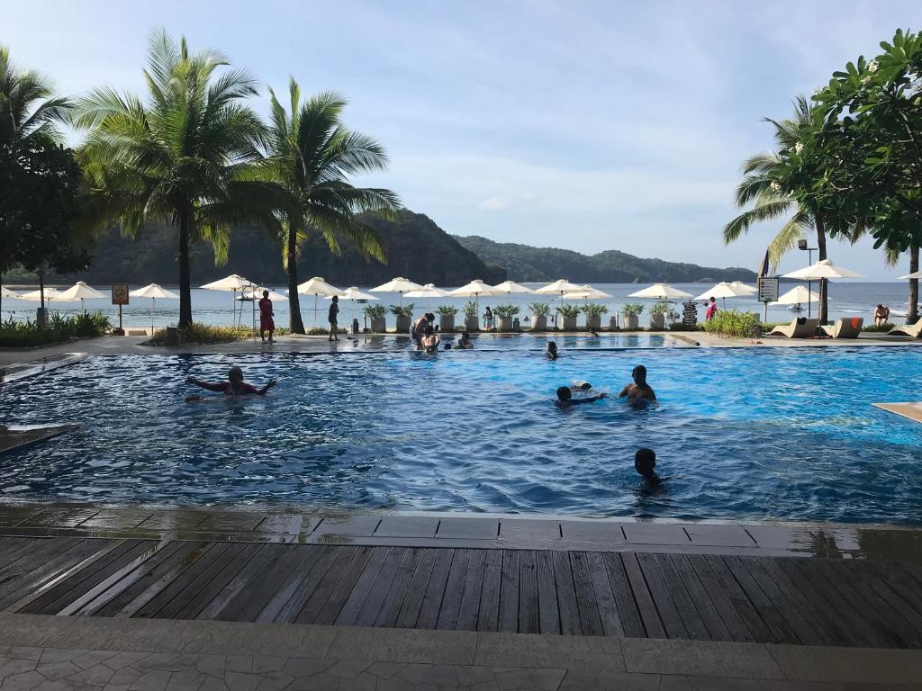 a group of people swimming in a swimming pool at ADC Condo 1 Bedroom Unit at Pico de Loro in Nasugbu