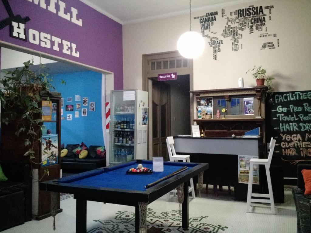 Habitación con mesa de ping pong y nevera. en Windmill Hostel en Mendoza