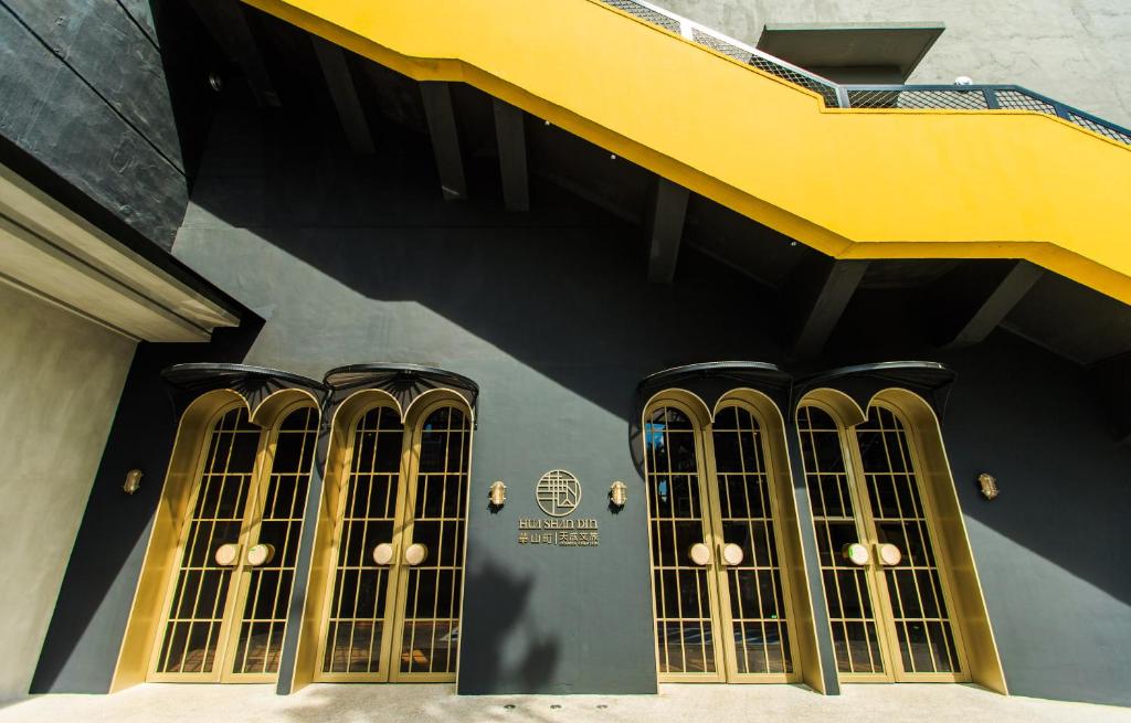 een gebouw met vier ramen en een gele trap bij Hua Shan Din by Cosmos Creation - Huashan Creative Park in Taipei