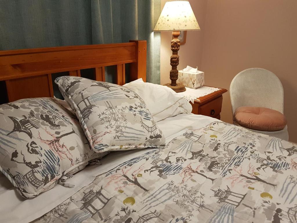 un letto con piumone e cuscini sopra di 59 Chaucer Apartment a Cambridge