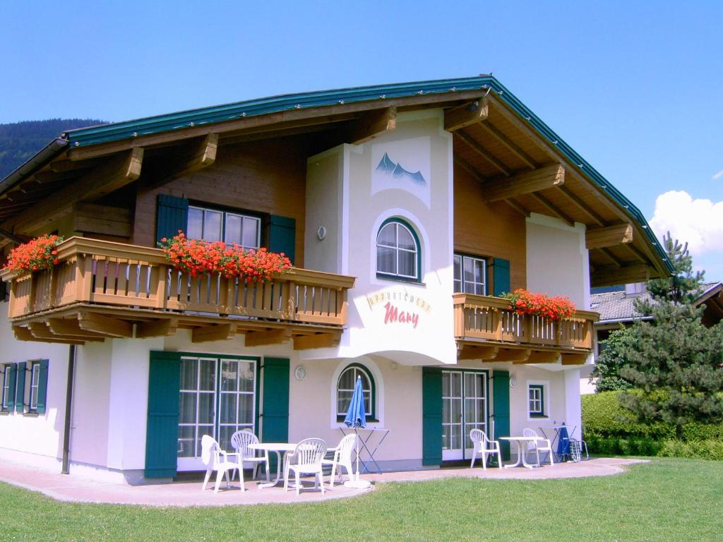 Appartements Mary inklusive Tauern-Spa Kaprun في كابرون: مبنى مع شرفة وطاولات وكراسي