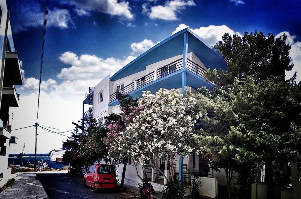 a red car parked in front of a blue and white building at Poseidon Hotel in Heraklio Town