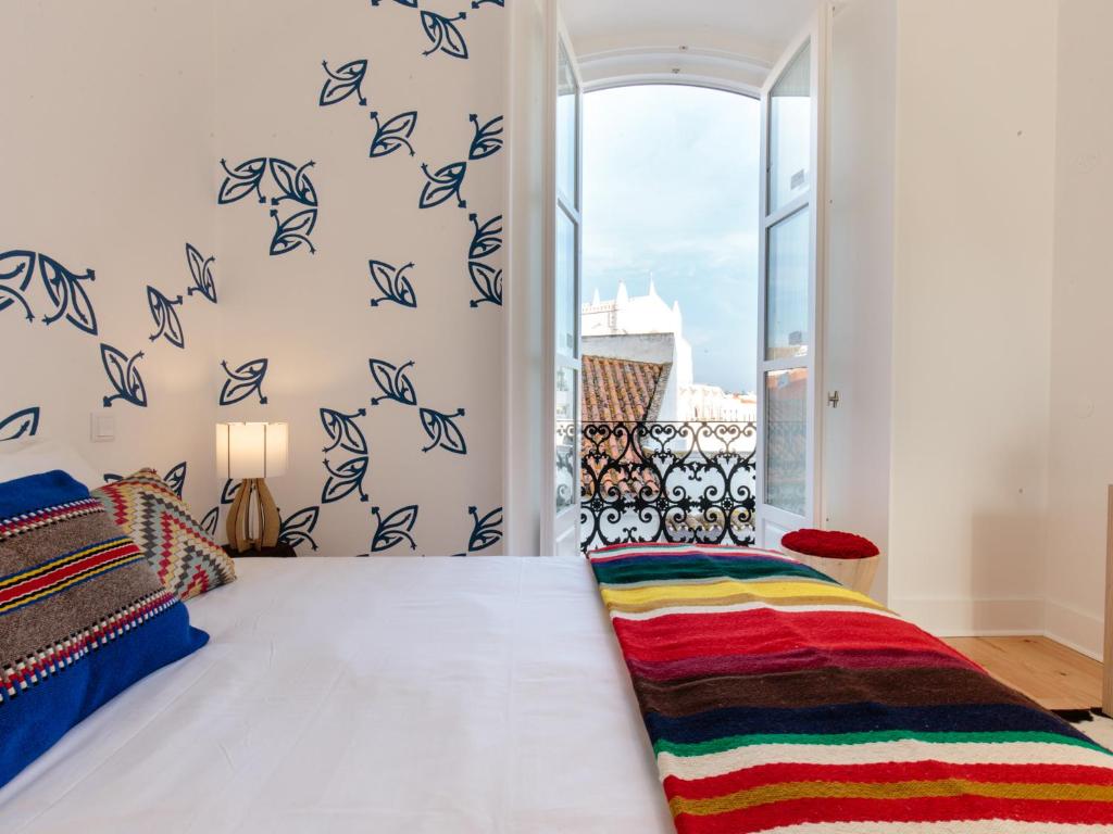 een slaapkamer met een bed en een raam met vogels aan de muur bij Heaven Inn Suites & Terrace in Évora