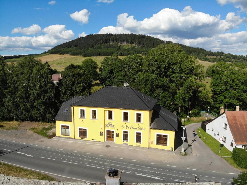 una vista aérea de un edificio amarillo al lado de una carretera en U Čmeláků, en Červená Voda