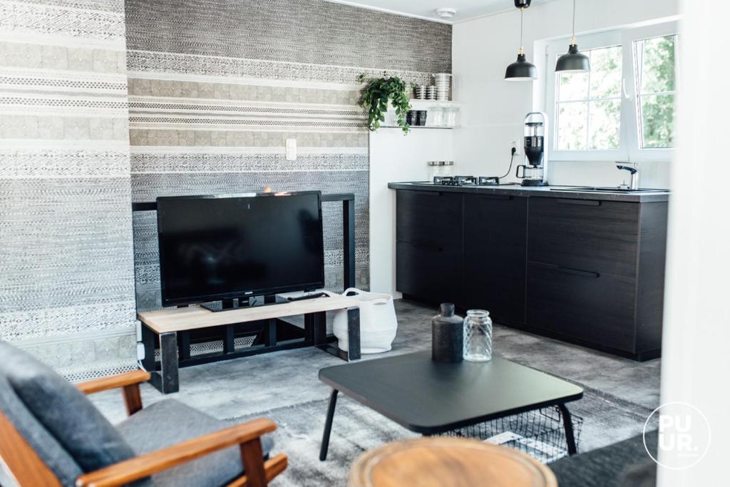 a living room with a television and a table at Nummer 100 - 1 in Leeuwarden