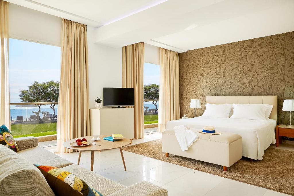 - une chambre avec un lit, un canapé et une télévision dans l'établissement Afitis Boutique Hotel, à Afytos