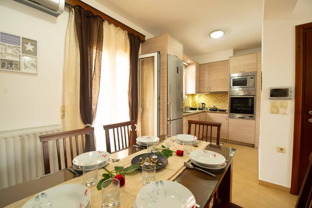 a kitchen with a dining room table with plates and bowls at Stefanos Family Apartments in Moírai