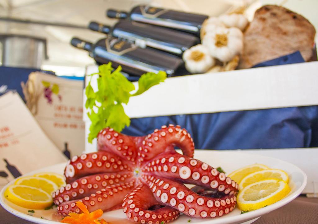 an octopus on a plate with oranges on a table at Corvino Resort in Monopoli