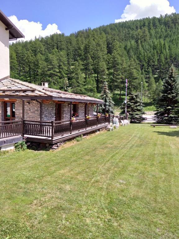 a house with a large yard next to a forest at Hotel Banchetta in Sestriere