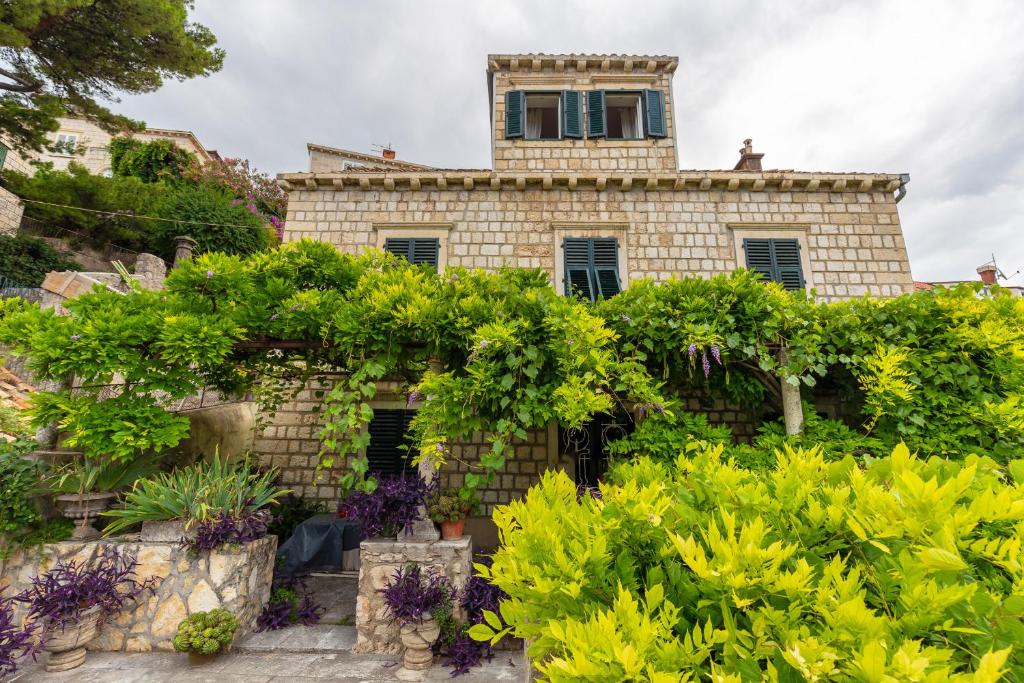 une maison ancienne avec un jardin en face dans l'établissement The Loft, à Dubrovnik