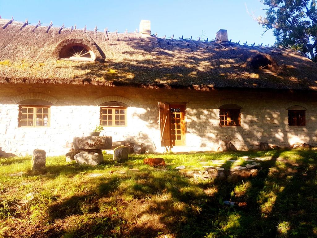 una antigua casa de piedra con techo de hierba en Paali cottages, en Tornimäe