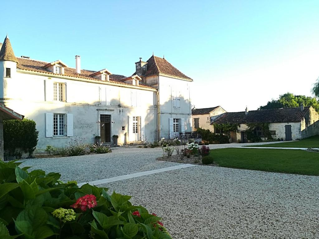 een groot wit huis met een grindoprit bij Domaine de Montboulard in Soyaux