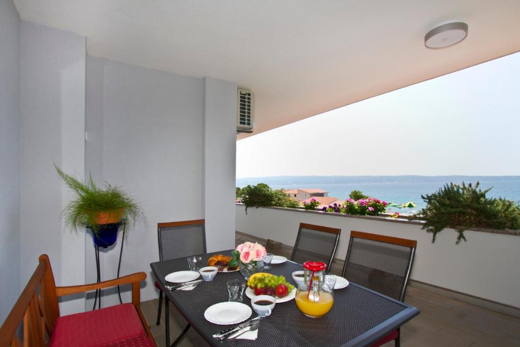 een eetkamer met een tafel en uitzicht op de oceaan bij Apartment Topic near the beach in Podstrana
