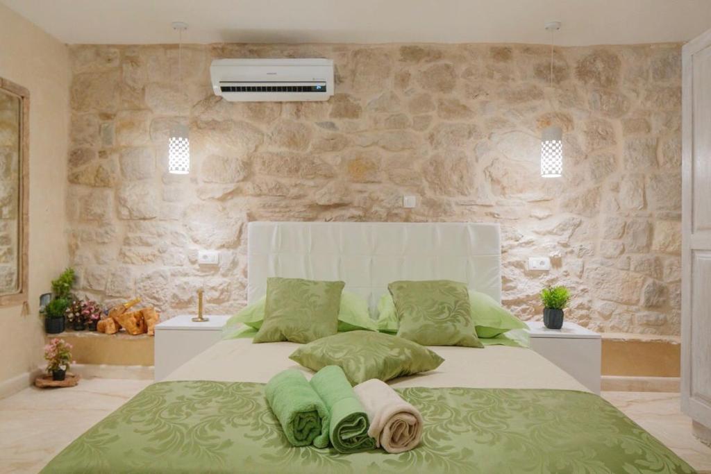 a bedroom with a large white bed with green pillows at Luxury View Marjan in Split