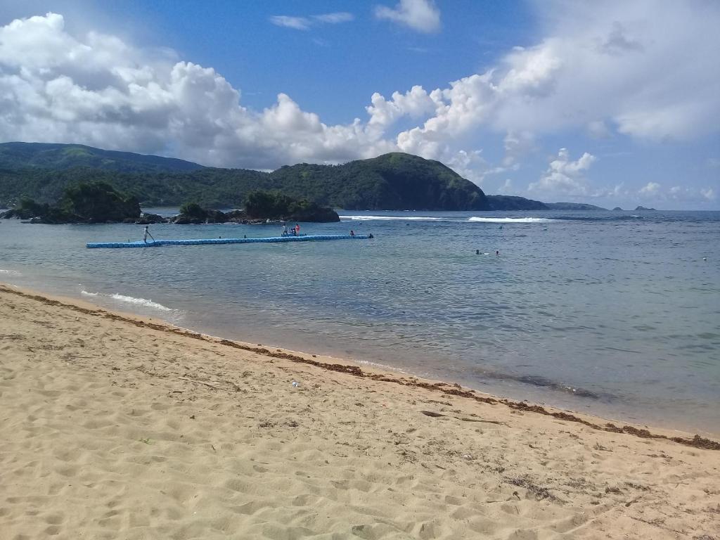 una playa con un barco en el agua en JoSurfInn, Puraran Beach, en Baras