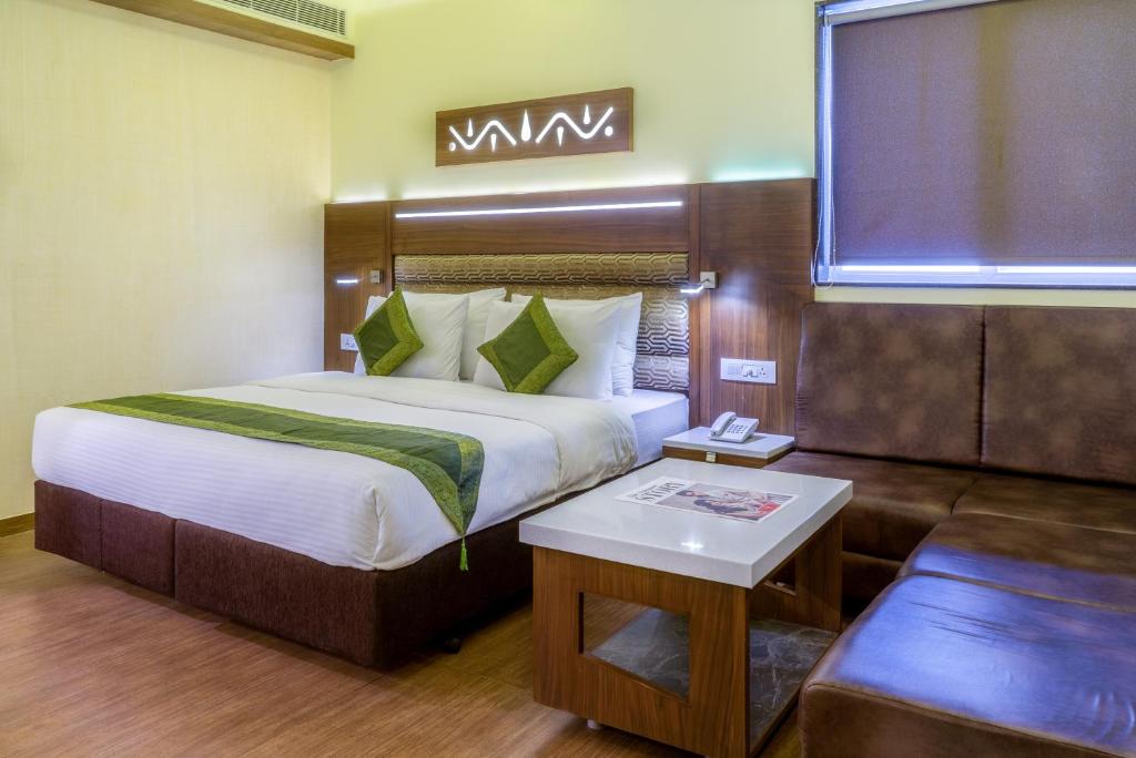 アーメダバードにあるTreebo Trend Ambassadorのベッドとソファ付きのホテルルーム