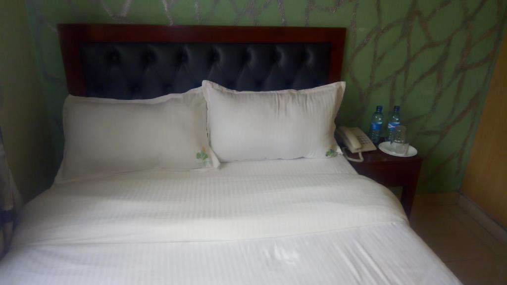 Postel nebo postele na pokoji v ubytování Ash White Hotel