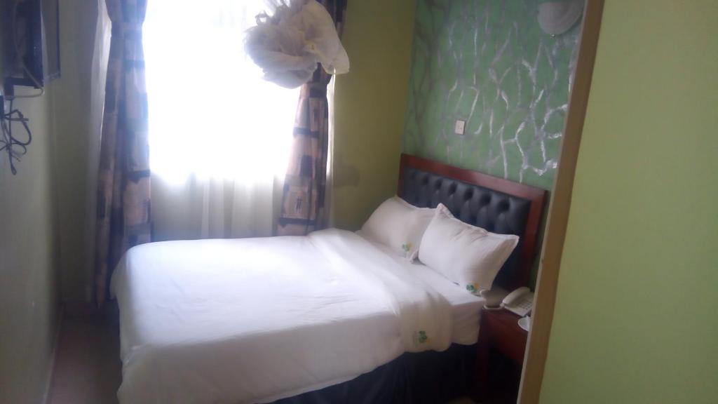 Postel nebo postele na pokoji v ubytování Ash White Hotel