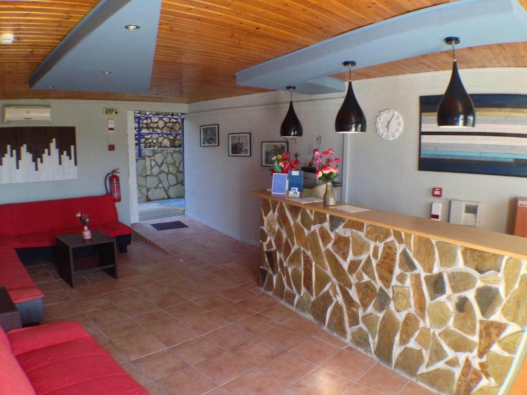 a bar in a restaurant with a red couch at Politia Hotel in Agios Nikitas