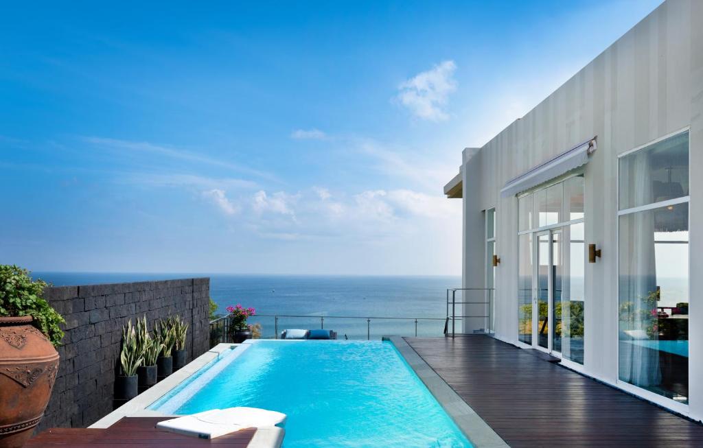 a swimming pool on the balcony of a house at Anantara Uluwatu Bali Resort in Uluwatu