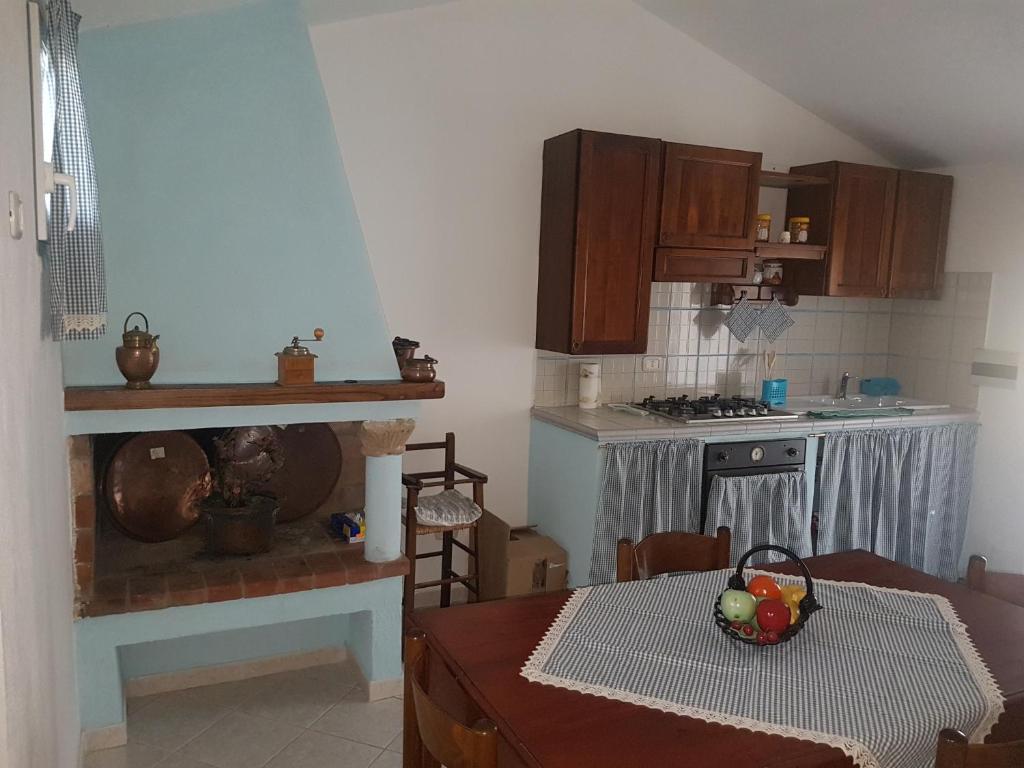 uma cozinha com uma mesa e uma cozinha com um fogão em La Casetta Blu em Capalbio