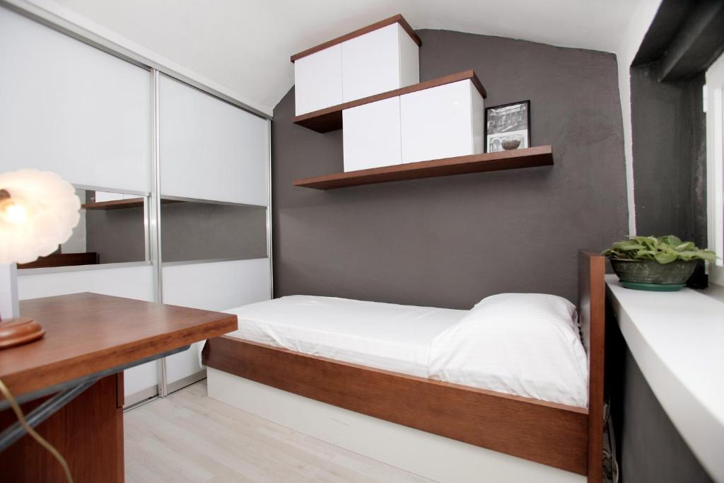 a small bedroom with a bed and shelves at Phaedra Apartment in Trogir
