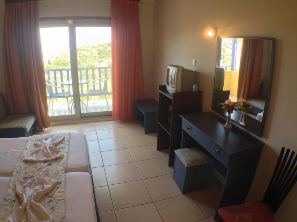 a room with a bed and a desk and a mirror at Politia Hotel in Agios Nikitas