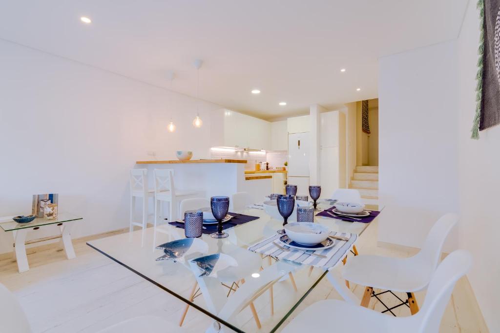 une salle à manger avec une table en verre et des chaises blanches dans l'établissement Villa V1 Vale do Lobo Beach, à Vale do Lobo