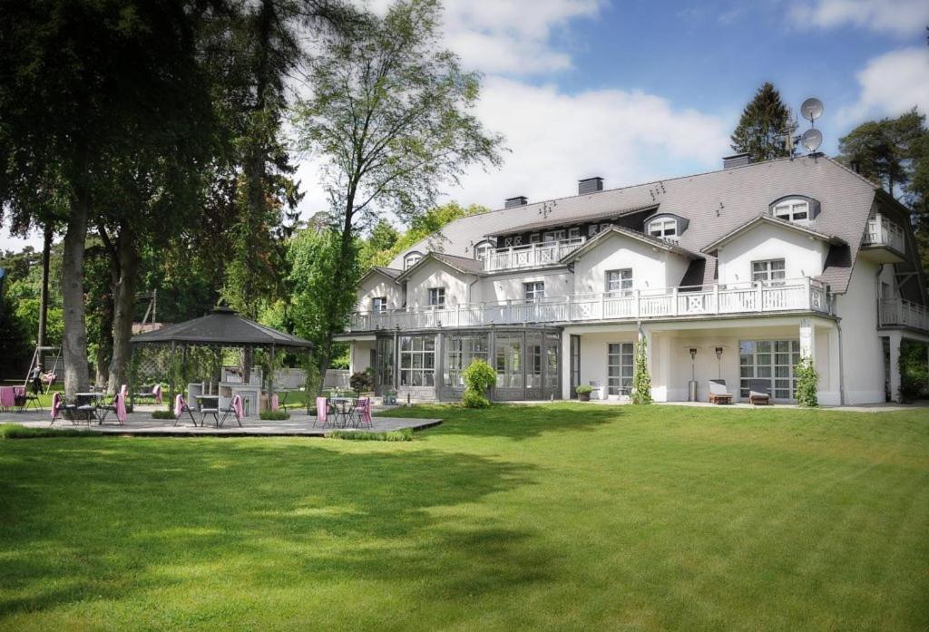 a large white house with a lawn in front of it at Villa Park Wisełka Spa & Wellness in Wisełka