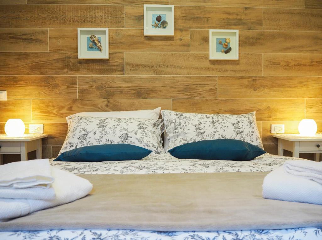 - un lit avec des oreillers bleus et blancs dans une chambre dans l'établissement LA BRIGATA APARTMENTS Yellow House, à Cavallino-Treporti