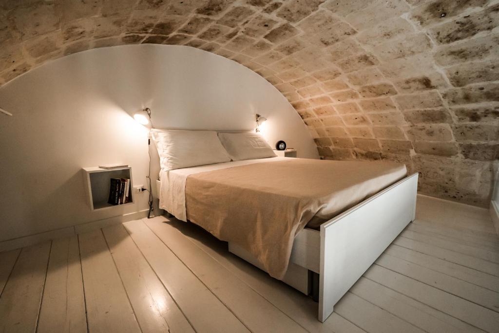 ein Schlafzimmer mit einem Bett in einer Ziegelwand in der Unterkunft Idris Loft Matera in Matera