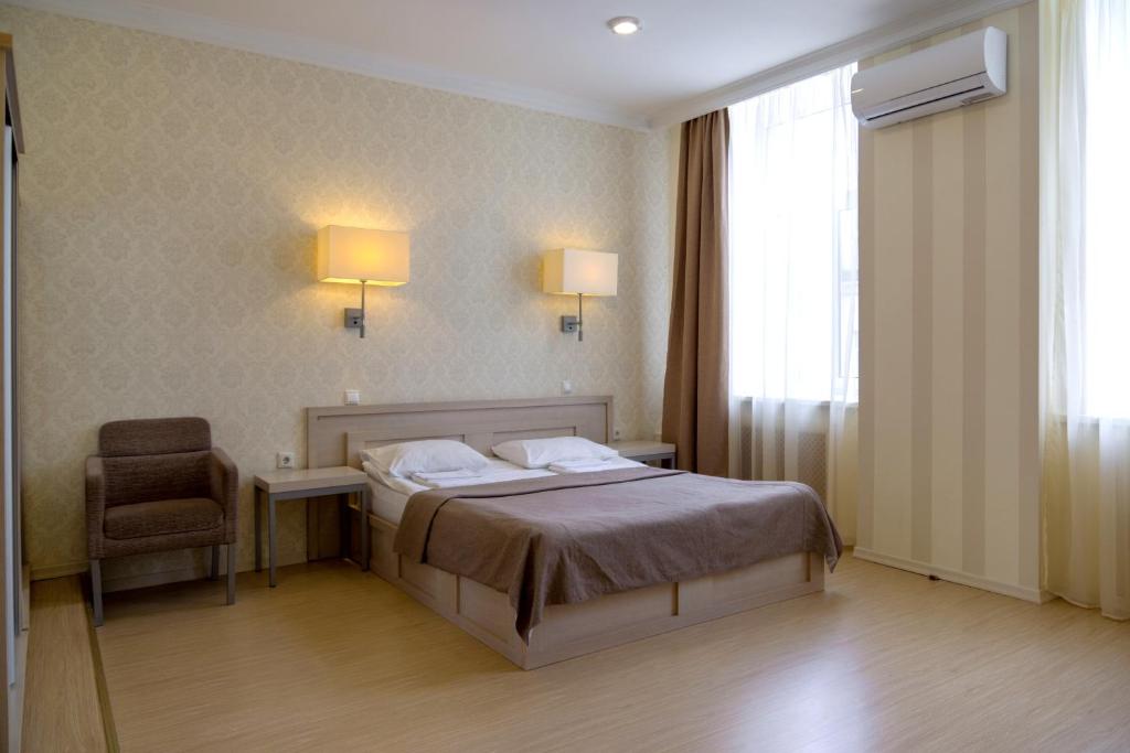 a bedroom with a bed and a desk and a chair at RA Nevsky 44 in Saint Petersburg