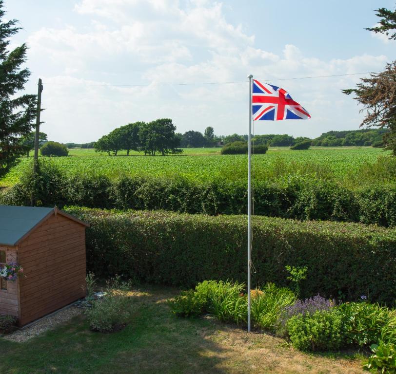 a british flag on a pole in a garden at Linden House in West Wittering