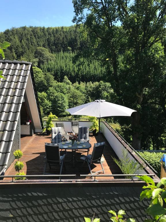 a patio with a table and chairs and an umbrella at Ferienwohnung Krähling in Schmallenberg