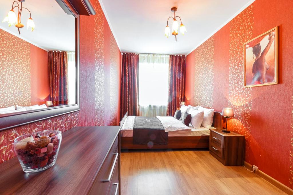 モスクワにあるInnDays on Kievskayaのベッドルーム1室(赤い壁のベッド1台、鏡付)