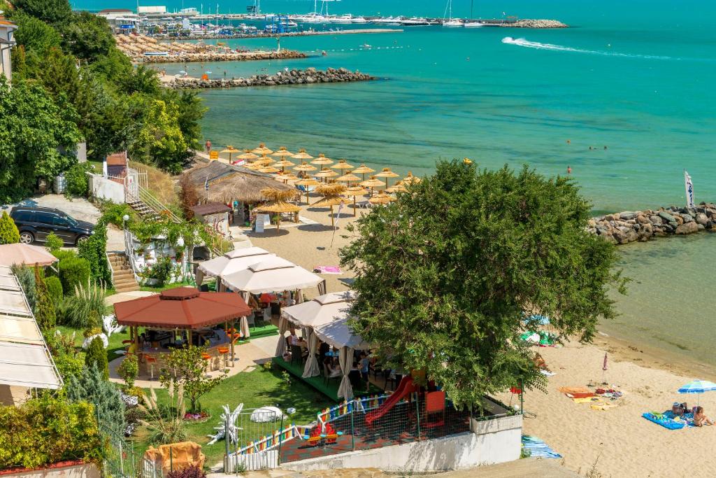 a beach with a bunch of umbrellas and the ocean at Iris Beach Hotel in Sveti Vlas