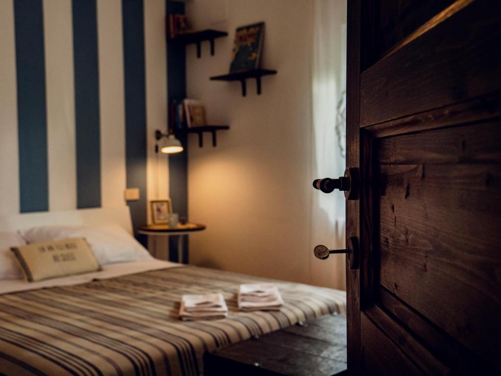 Alloggio del Fiume - Le Vecchie Vasche في Sassa: غرفة نوم بسرير من الخطوط الزرقاء والبيضاء