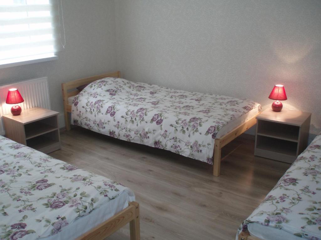 a bedroom with two beds and two tables with lamps at Centra House in Rēzekne