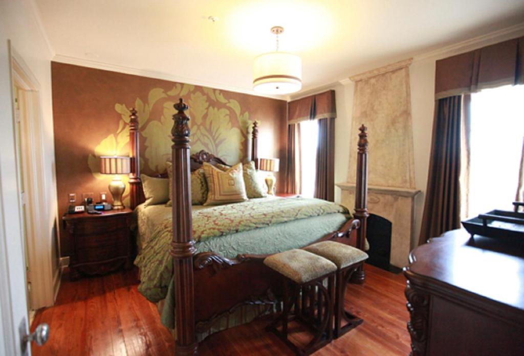 a bedroom with a bed and a dresser at The Campbell Hotel in Tulsa