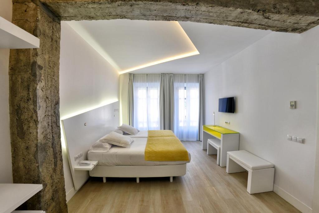 biała sypialnia z łóżkiem i biurkiem w obiekcie Atarazanas Málaga Boutique Hotel w Maladze