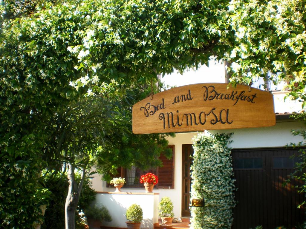 a house with a sign that reads put and breakfast mimosasu at Bed and Breakfast Mimosa in Cascina
