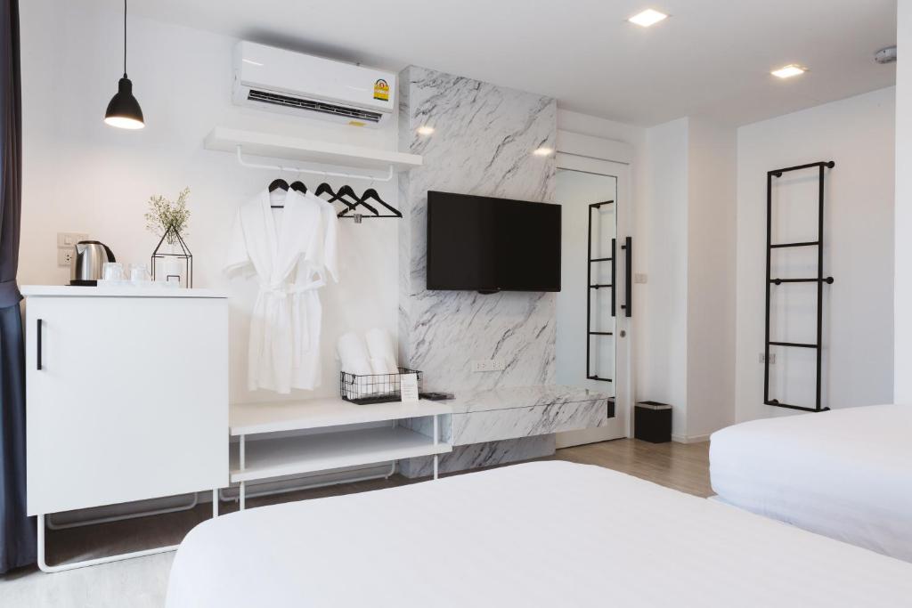 A clean-lined bedroom with twin beds, television and open storage.
