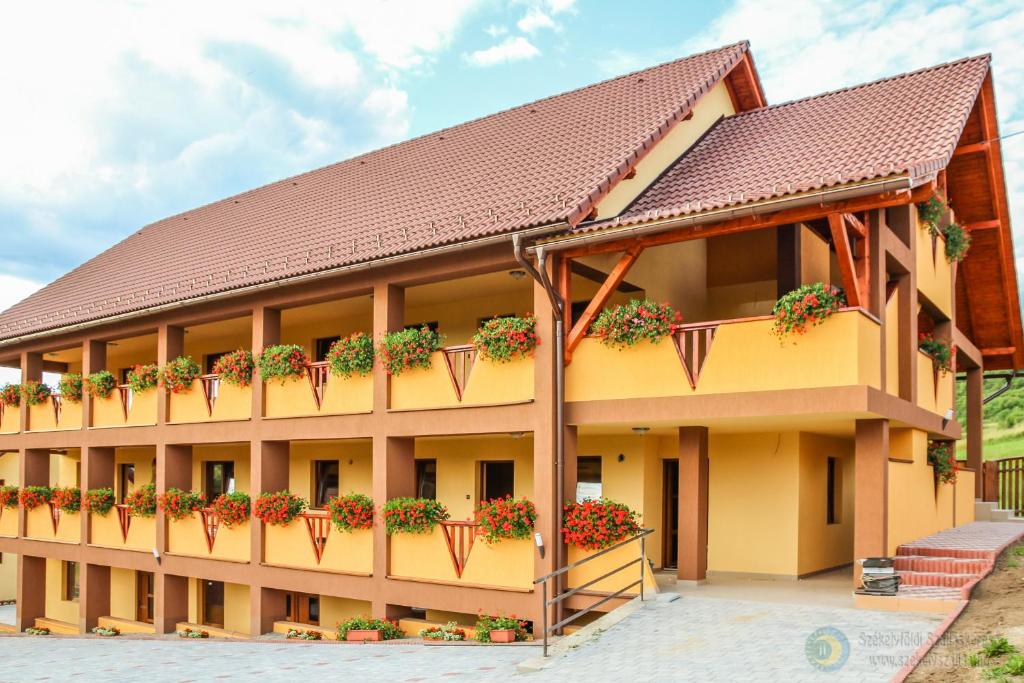 a building with potted plants on the balconies at Apartamente Manó Apartmanok in Praid