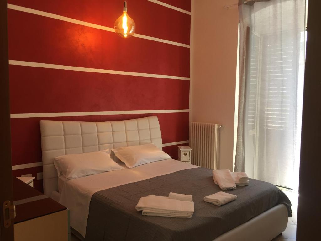 sypialnia z łóżkiem z czerwonymi i białymi paskami w obiekcie casasuisassi w mieście Matera