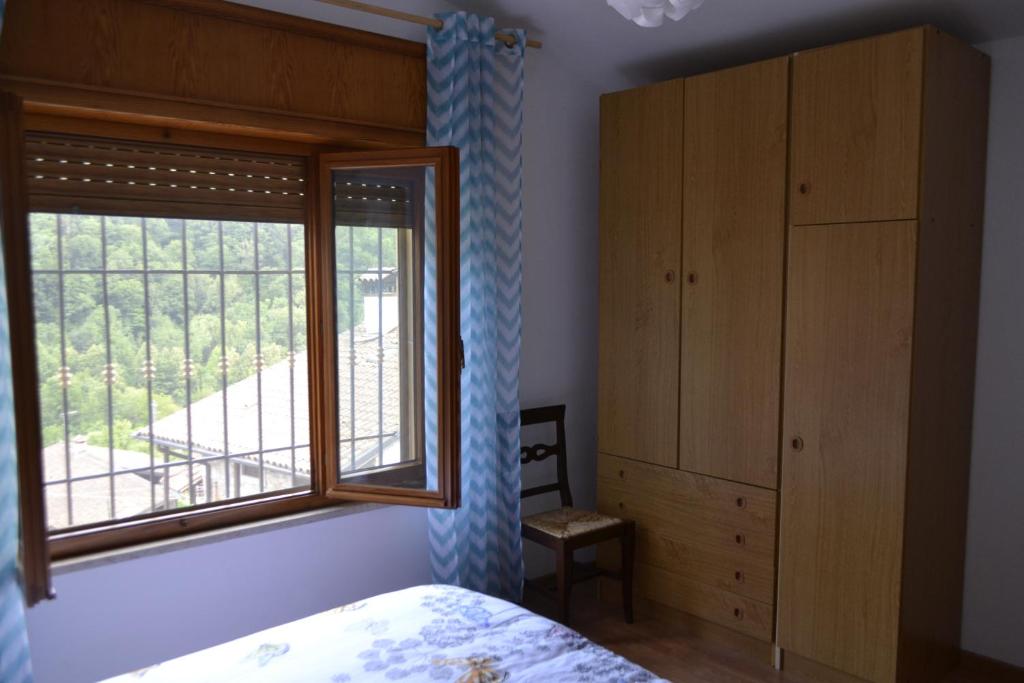 Schlafzimmer mit einem Bett und einem Fenster in der Unterkunft Alloggio da Massimo in San Leonardo