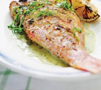 un piatto bianco con un pezzo di pesce con i fiori di Chambre d'hôte Kay Arlette - chez l'habitant a Le Robert